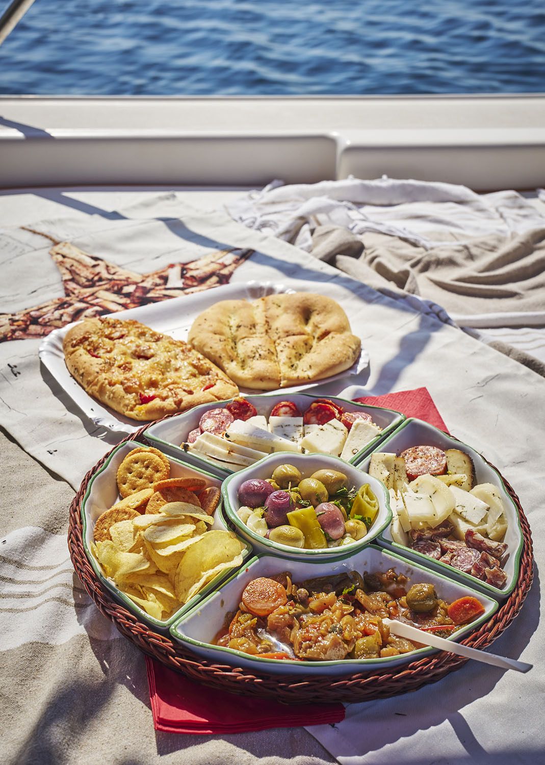 Tagliere di aperitivo con focaccia, formaggi, salumi, olive e caponata a bordo