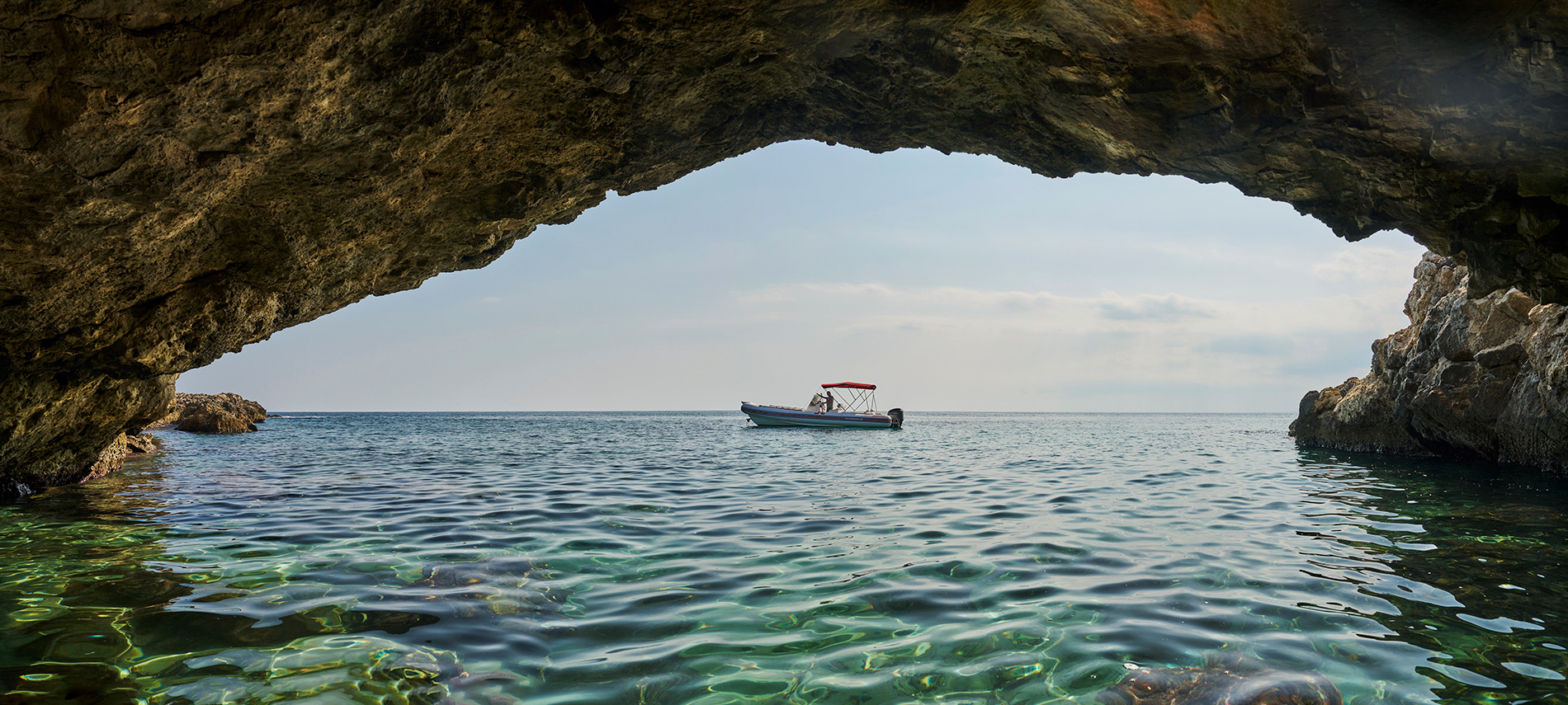 Vista del gommone vista da dentro una grotta marina di Siracusa