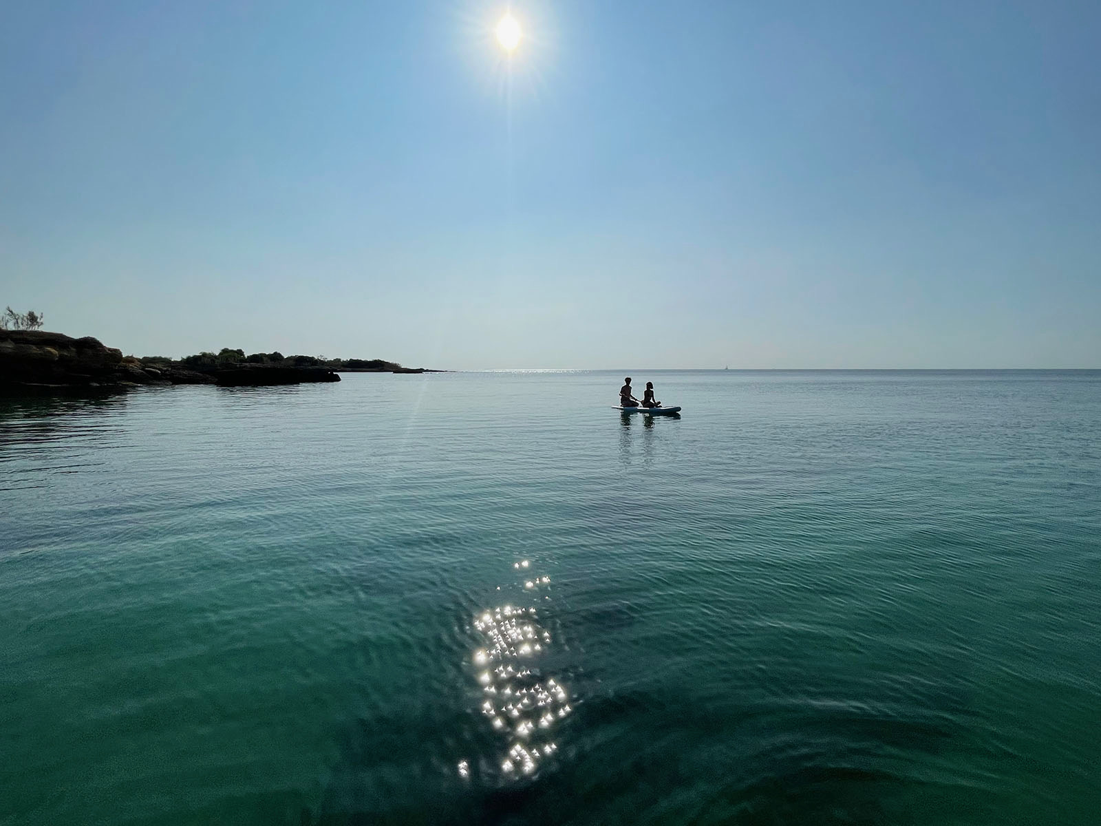Coppia su tavola SUP al tramonto sul mare di Sicilia