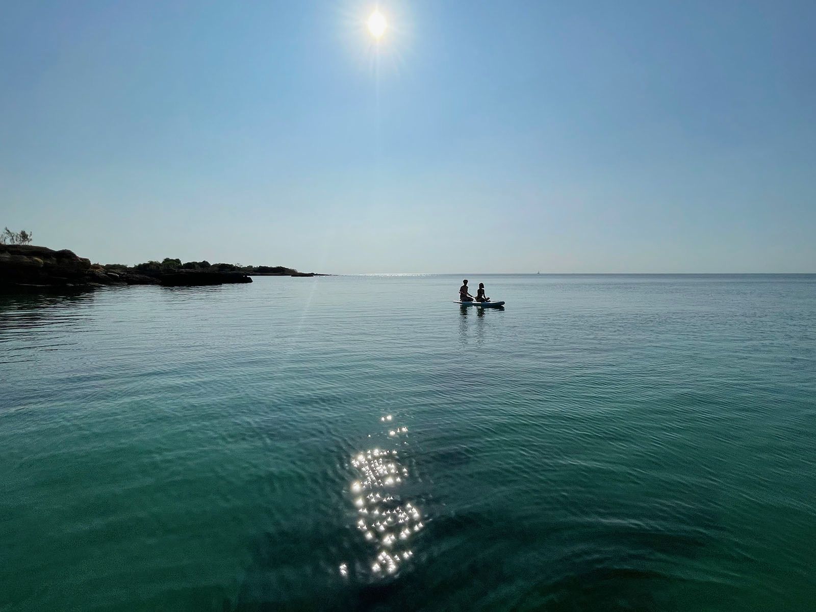 Coppia su tavola SUP al tramonto sul mare di Sicilia